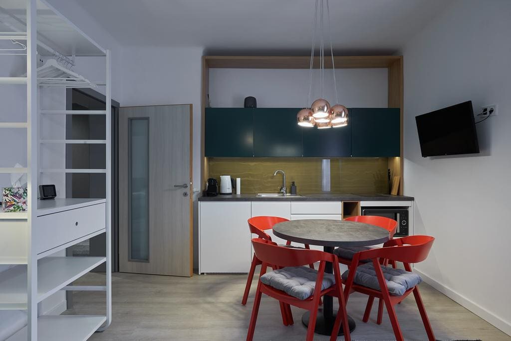 7Domb második apartman — konyha sárgaréz hátlappal, piros székekkel, rézgömb lámpákkal