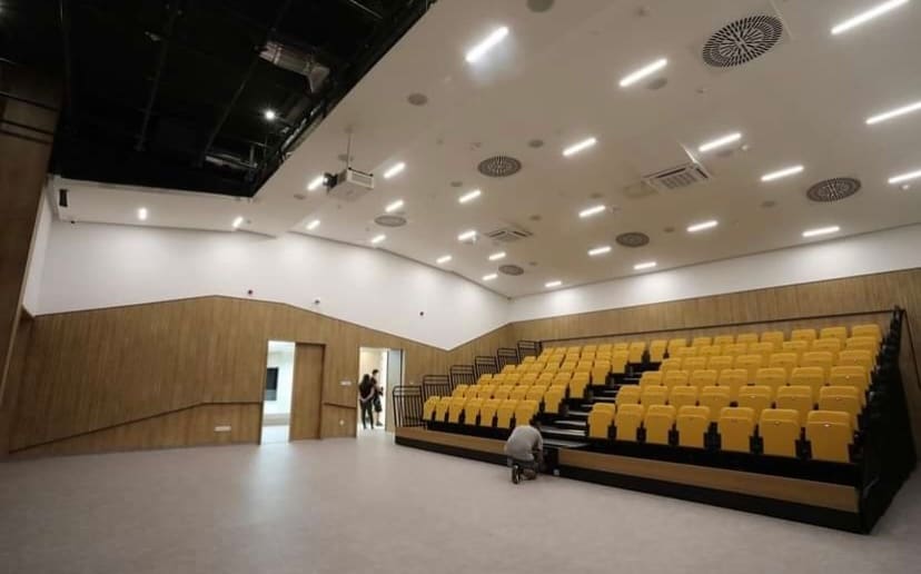 Kaptár Előadóterem — előadóterem oldalnézetből, teleszkópos lelátó behúzva sárga billenőszékekkel, üres parkett