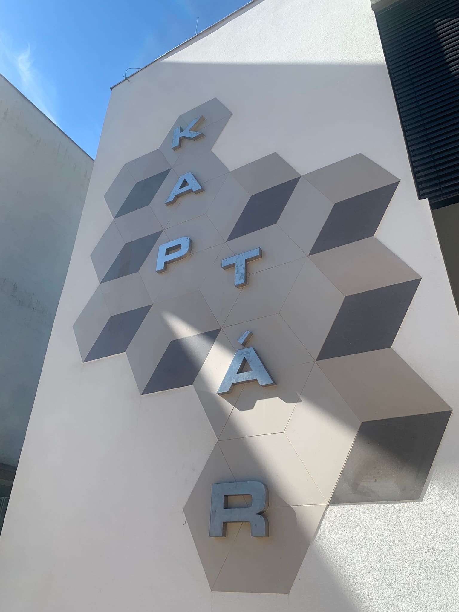 Kaptár — épülethomlokzat, hatszögű plasztikus burkolaton KAPTÁR betűk