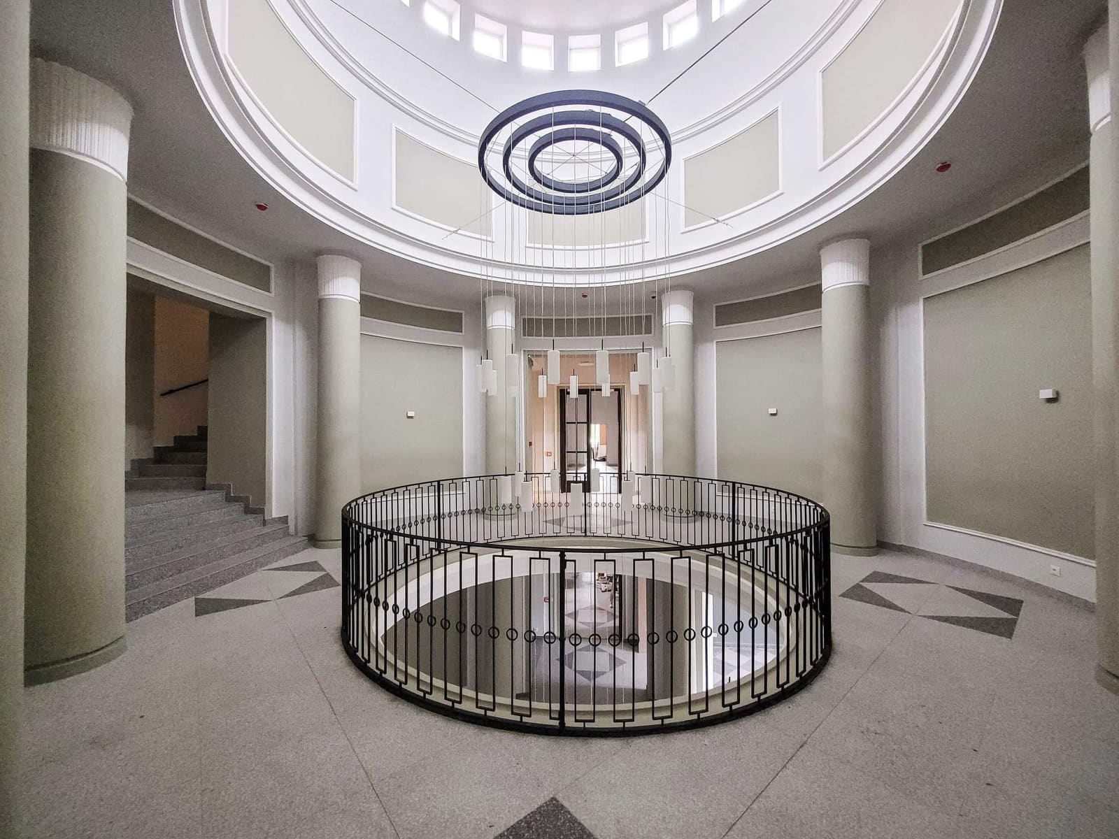 Komlói Múzeum aula — körkorlát a galéria alól, oszlopok, terrazzo padló, kupola csillár