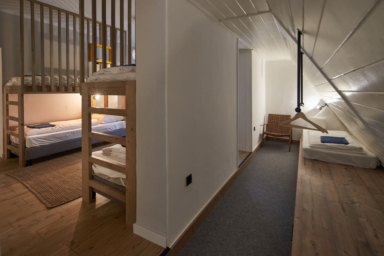 Zöld Béka — galériás közlekedő, emeletes ágyrendszer fa szerkezettel, sátortetős mennyezet, mosott szürke szőnyegcsík